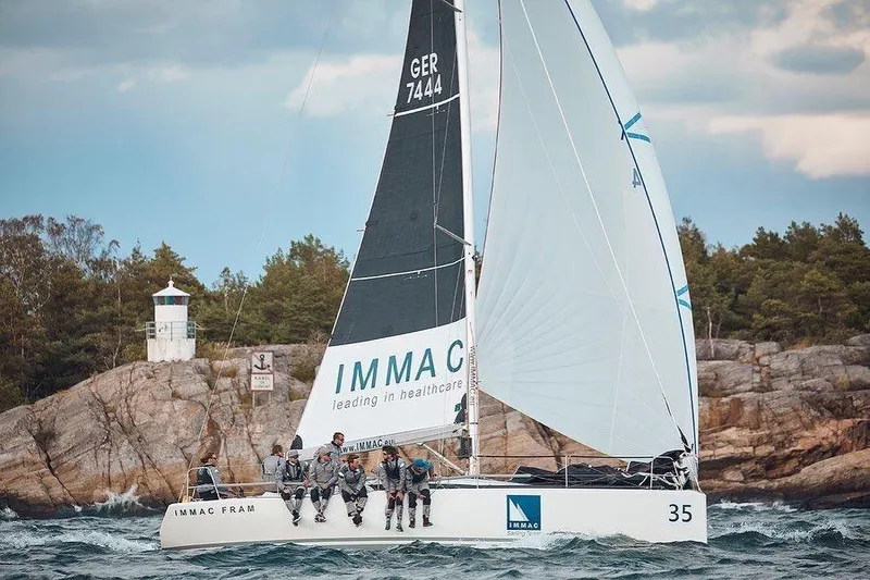 Slide: The Image of Italia Yachts 9.98 sailing near rocky coastline, 2026 model, with crew onboard. - 5