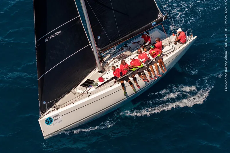 Slide: The Image of Italia Yachts 9.98 sailing with crew, 2026 model, in a competitive race. - 7