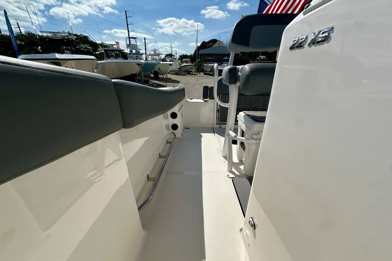 Slide: The Image of 2024 NauticStar 222 Offshore boat interior with seating and console, under a sunny sky. - 10