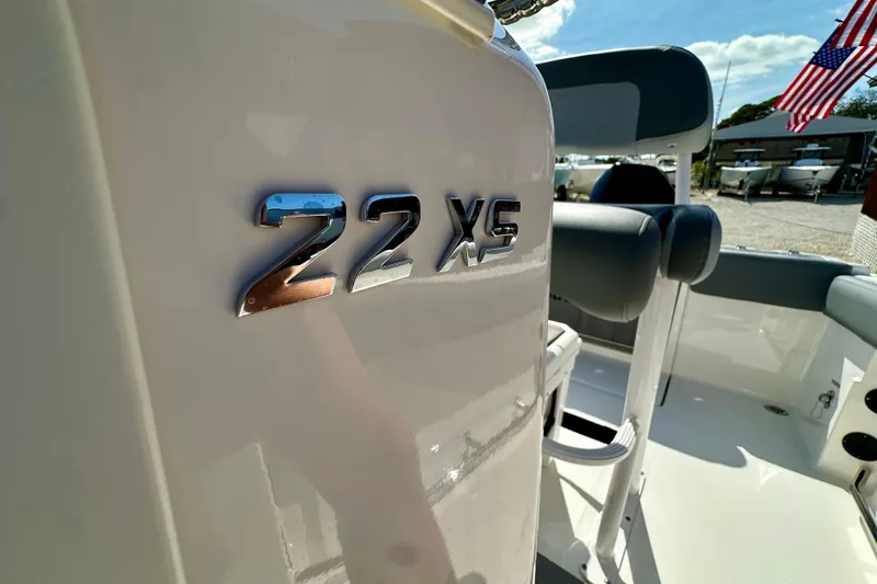 Slide: The Image of 2024 NauticStar 222 Offshore boat interior with "22 XS" emblem, American flag in background. - 4