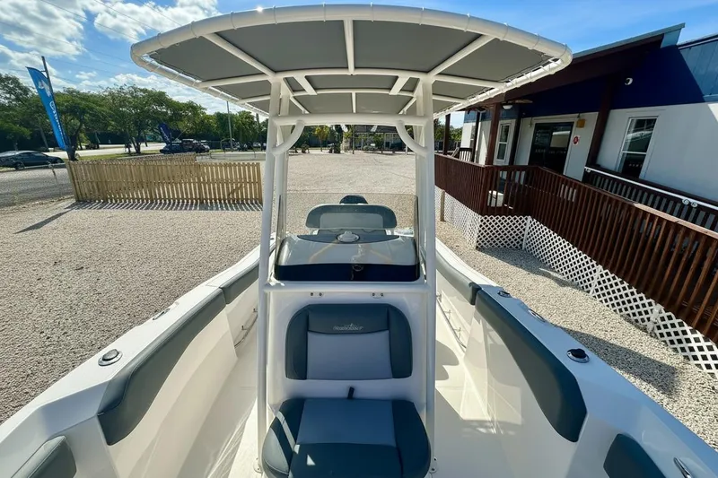 Slide: The Image of 2024 NauticStar 222 Offshore boat with T-top and seating, displayed outdoors. - 6