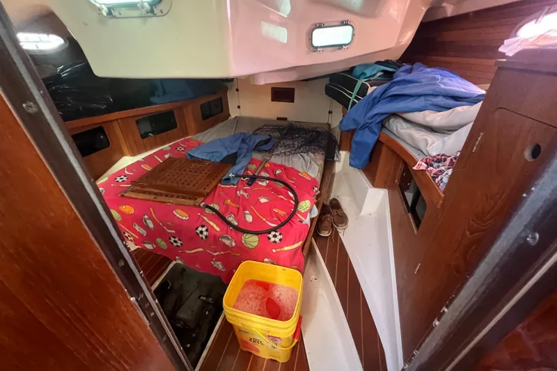Slide: The Image of Interior of 1987 Hunter Legend 37 sailboat with colorful bedding and cleaning supplies. - 15
