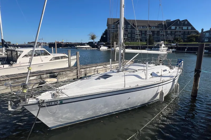 Slide: The Image of 1987 Hunter Legend 37 sailboat docked in a marina under clear blue skies. - 2