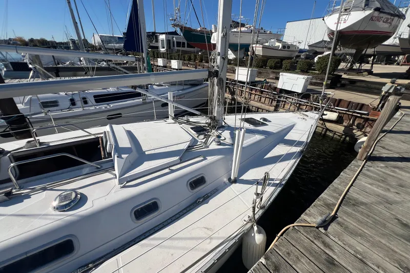 Slide: The Image of 1987 Hunter Legend 37 sailboat docked at marina under clear blue sky. - 4