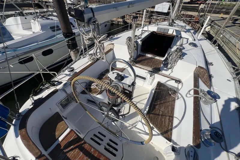 Slide: The Image of 1987 Hunter Legend 37 sailboat cockpit with steering wheel and rigging, docked at marina. - 7