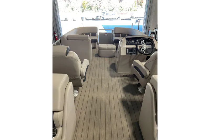 Slide: The Image of 2019 Bennington SX 23 SSRXP pontoon boat interior with beige seating in a garage. - 5
