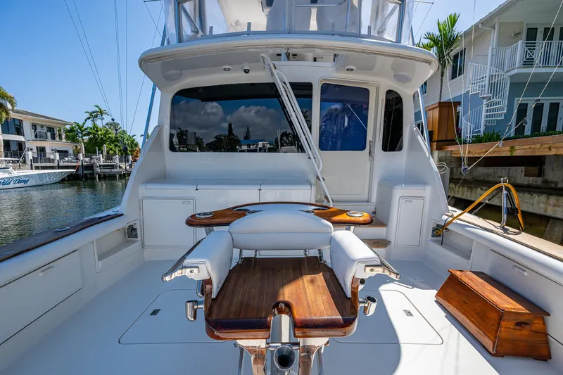 Slide: The Image of 1999 Ocean Yachts 60 Convertible fishing deck with chair, docked in a sunny marina. - 13