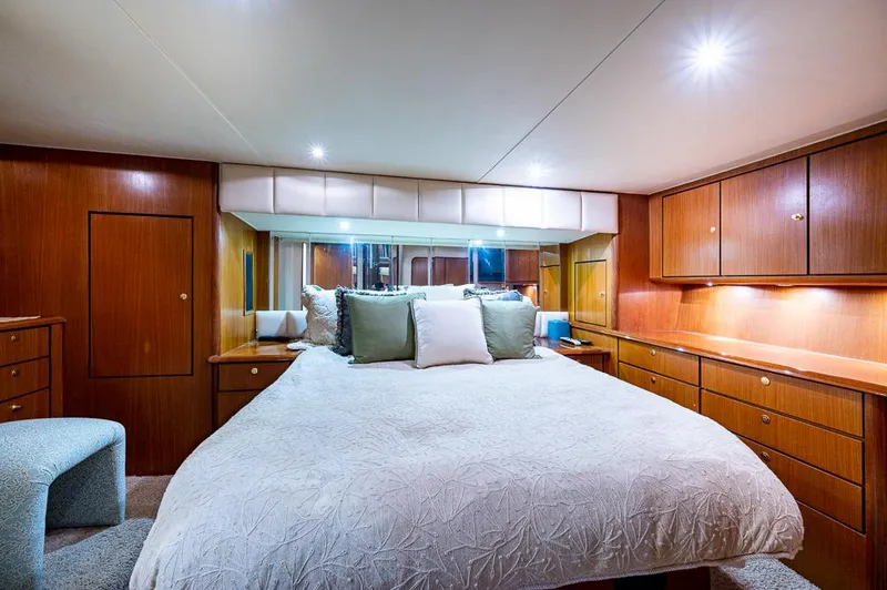 Slide: The Image of Luxurious bedroom interior of 1999 Ocean Yachts 60 Convertible with wood cabinetry and plush bedding. - 26
