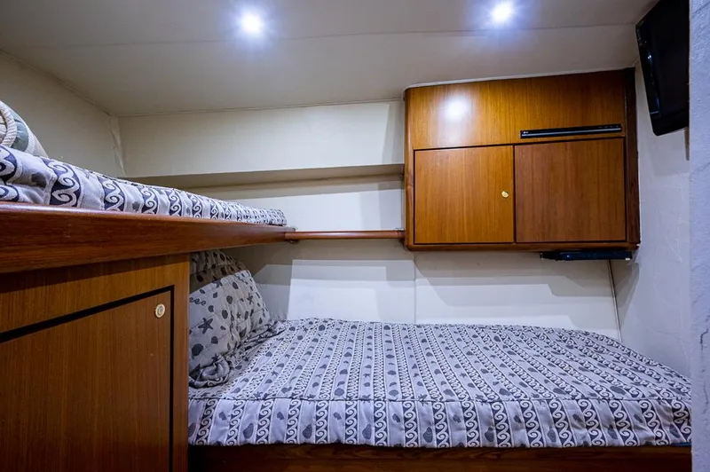 Slide: The Image of 1999 Ocean Yachts 60 Convertible cabin with bunk beds and wooden cabinetry. - 35