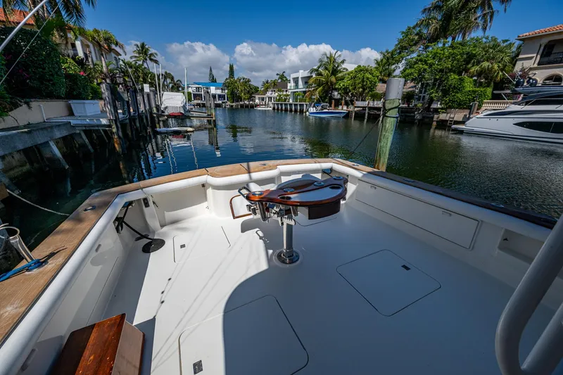 Slide: The Image of 1999 Ocean Yachts 60 Convertible docked in a scenic marina, surrounded by palm trees. - 11