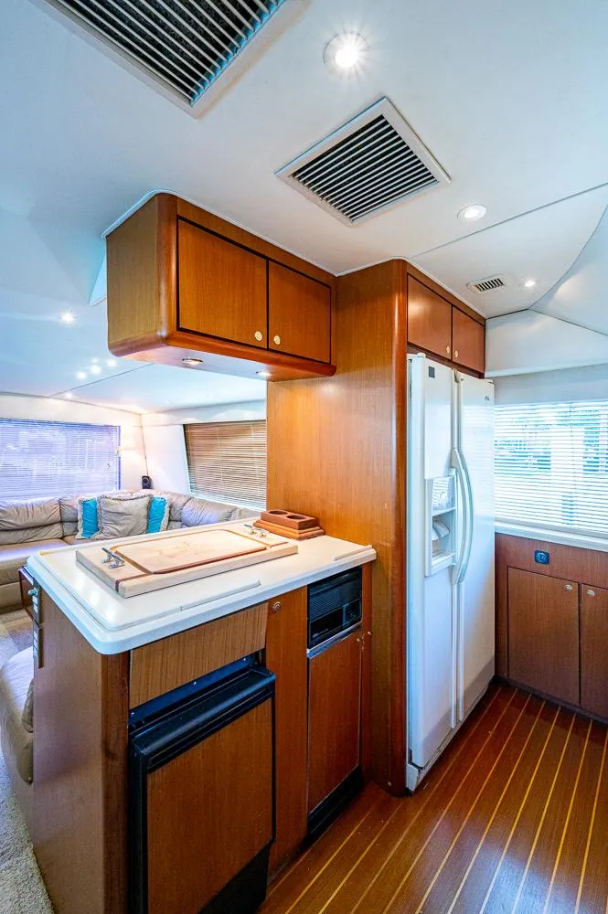 Slide: The Image of 1999 Ocean Yachts 60 Convertible interior with modern kitchen and wood accents. - 22