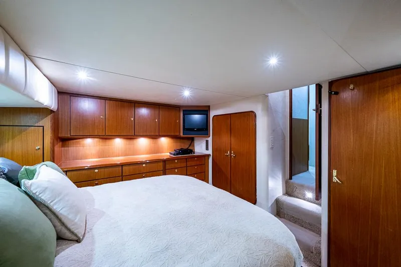 Slide: The Image of Luxurious cabin interior of 1999 Ocean Yachts 60 Convertible with wood cabinetry and cozy bedding. - 3