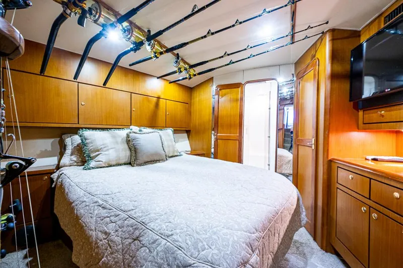 Slide: The Image of Luxurious bedroom interior of 1999 Ocean Yachts 60 Convertible with wood cabinetry and fishing rods. - 30