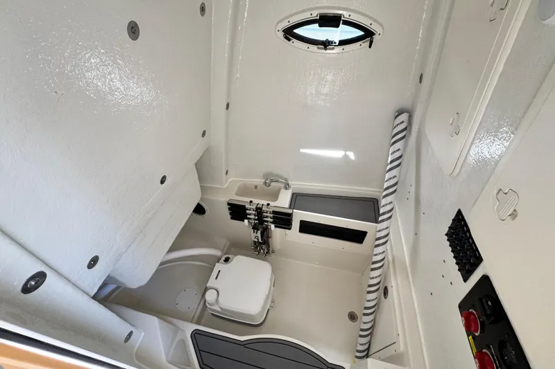 Slide: The Image of Interior of 2026 Sailfish 272 CC boat, featuring compact marine toilet and storage. - 28