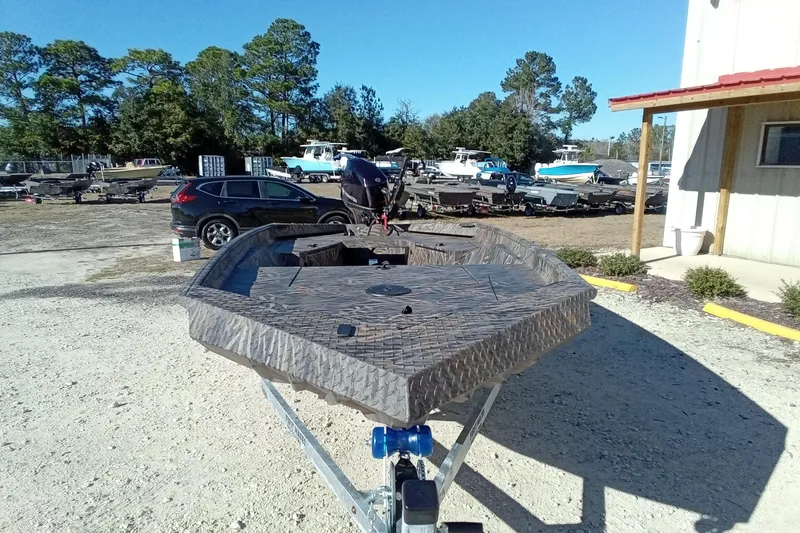 Slide: The Image of 2026 Alweld 1552 Invader boat on trailer, parked outdoors near a building. - 5