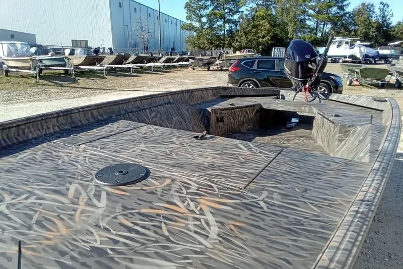 Slide: The Image of 2026 Alweld 1552 Invader boat with camouflage design in outdoor storage area. - 6