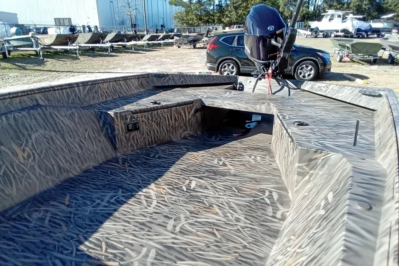 Slide: The Image of 2026 Alweld 1552 Invader boat with camouflage interior, parked outdoors. - 7