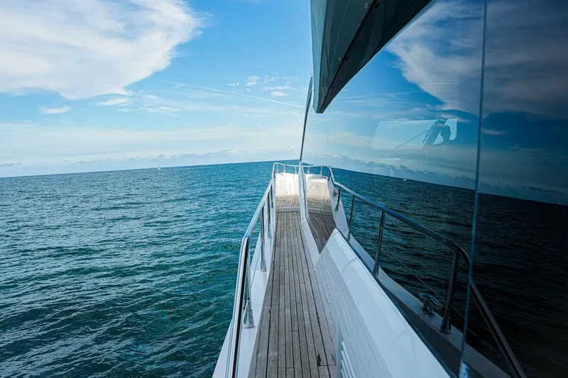 Slide: The Image of Side view of 2019 Sunseeker 76 Yacht cruising on open sea under blue sky. - 22