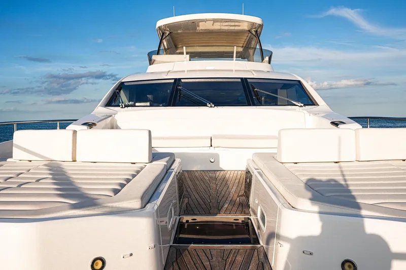Slide: The Image of 2019 Sunseeker 76 Yacht with luxurious deck and seating, under a clear blue sky. - 24