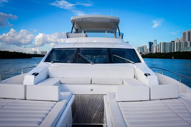 Slide: The Image of 2019 Sunseeker 76 Yacht cruising near city skyline under blue sky. - 25