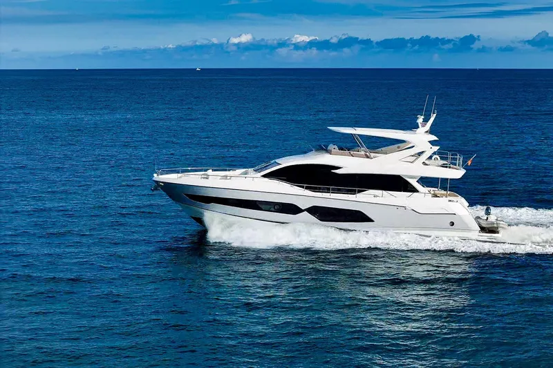 Slide: The Image of 2019 Sunseeker 76 Yacht cruising on open sea under clear blue sky. - 6
