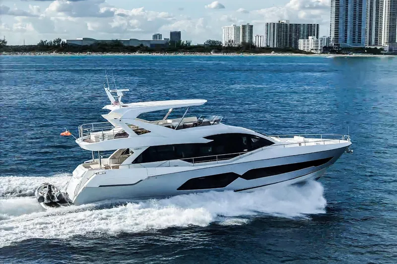 Slide: The Image of 2019 Sunseeker 76 Yacht cruising on blue ocean near city skyline. - 7