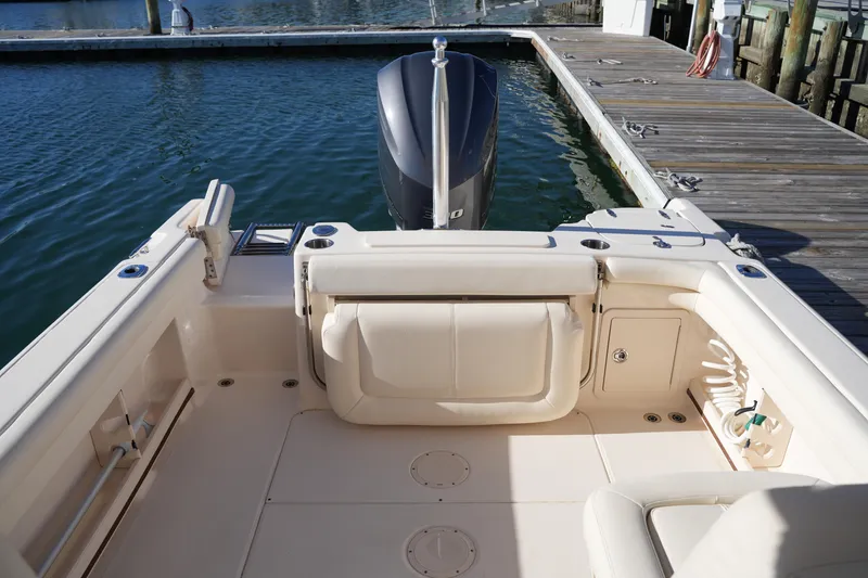 Slide: The Image of 2016 Grady-White Freedom 255 boat interior at dock, showcasing seating and engine area. - 18
