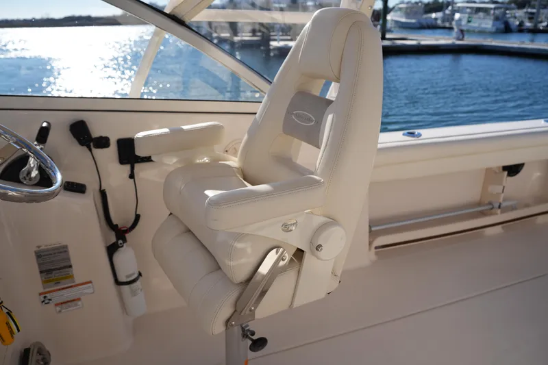 Slide: The Image of Captain's chair on 2016 Grady-White Freedom 255 boat, overlooking marina waters. - 25