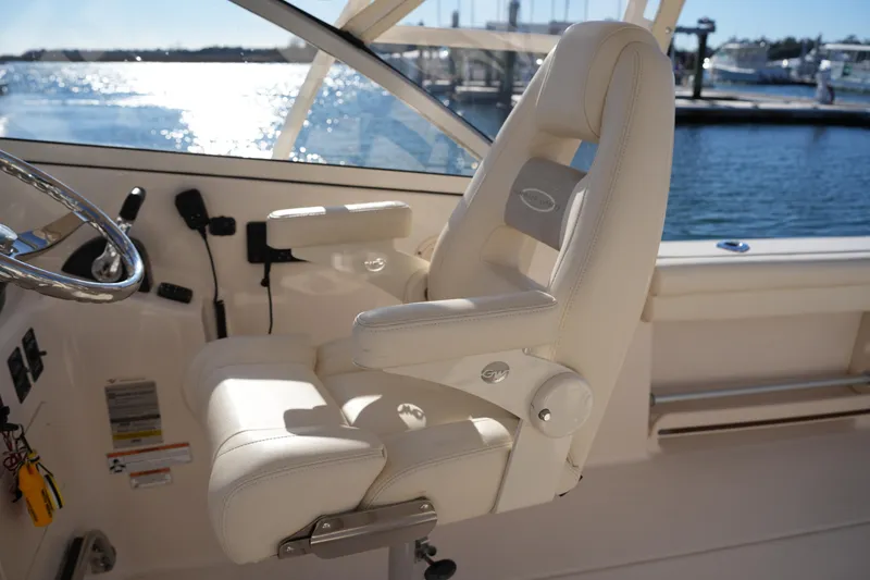 Slide: The Image of Captain's chair on 2016 Grady-White Freedom 255 boat, overlooking marina waters. - 26