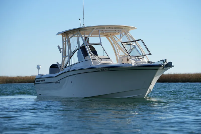 Slide: The Image of 2016 Grady-White Freedom 255 boat on calm water under clear blue sky. - 5
