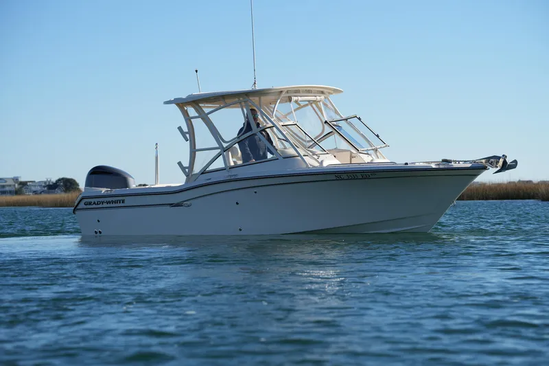 Slide: The Image of 2016 Grady-White Freedom 255 boat cruising on calm waters under clear blue sky. - 6