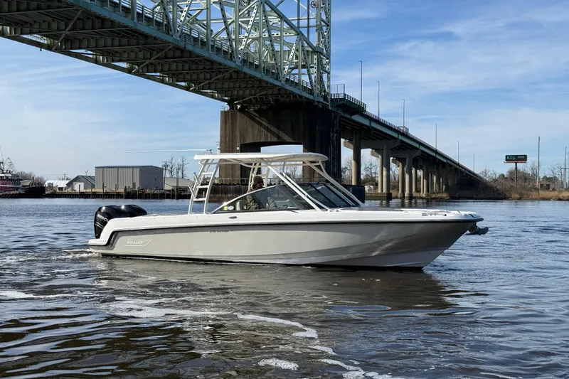 The Image of 2014 Boston Whaler 270 Vantage boat cruising under a bridge on a sunny day. - 0