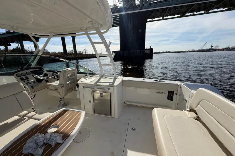 Slide: The Image of 2014 Boston Whaler 270 Vantage boat interior under bridge, featuring seating and helm. - 11