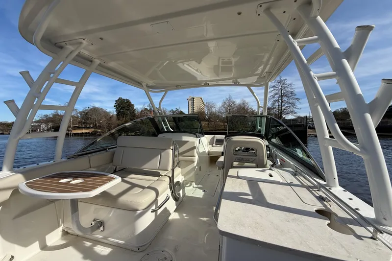 Slide: The Image of 2014 Boston Whaler 270 Vantage boat interior with seating and table on a sunny day. - 14