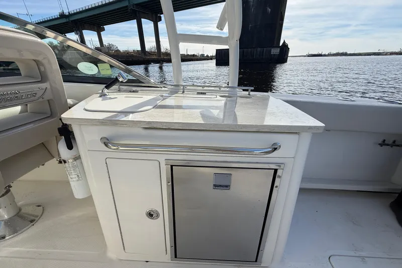 Slide: The Image of 2014 Boston Whaler 270 Vantage boat interior with kitchenette and water view. - 15