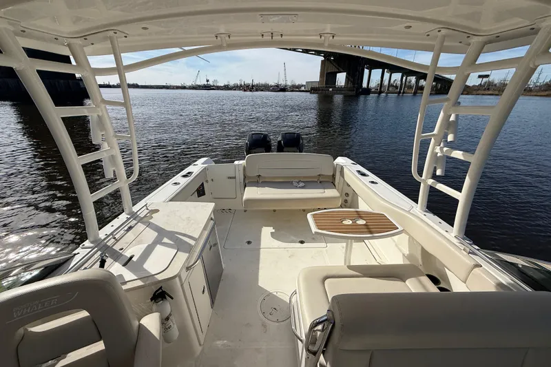 Slide: The Image of 2014 Boston Whaler 270 Vantage boat interior with seating, table, and water view. - 23