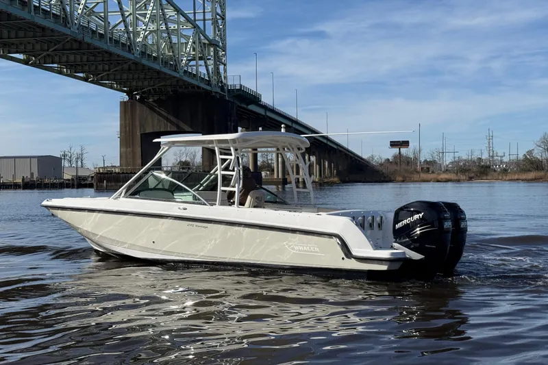 Slide: The Image of 2014 Boston Whaler 270 Vantage boat cruising under a bridge on a calm river. - 5
