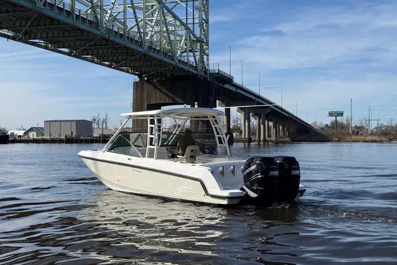 Slide: The Image of 2014 Boston Whaler 270 Vantage boat cruising under a bridge on a calm river. - 6