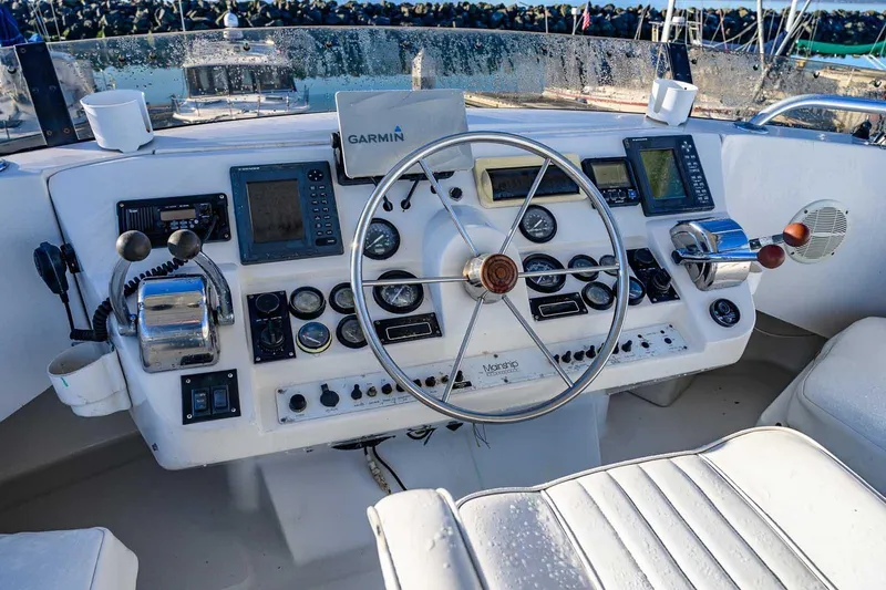 Slide: The Image of 1997 Mainship 350 Trawler helm with steering wheel, gauges, and navigation equipment. - 19