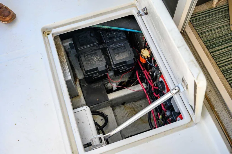 Slide: The Image of Battery compartment of a 1997 Mainship 350 Trawler with wiring and components visible. - 24