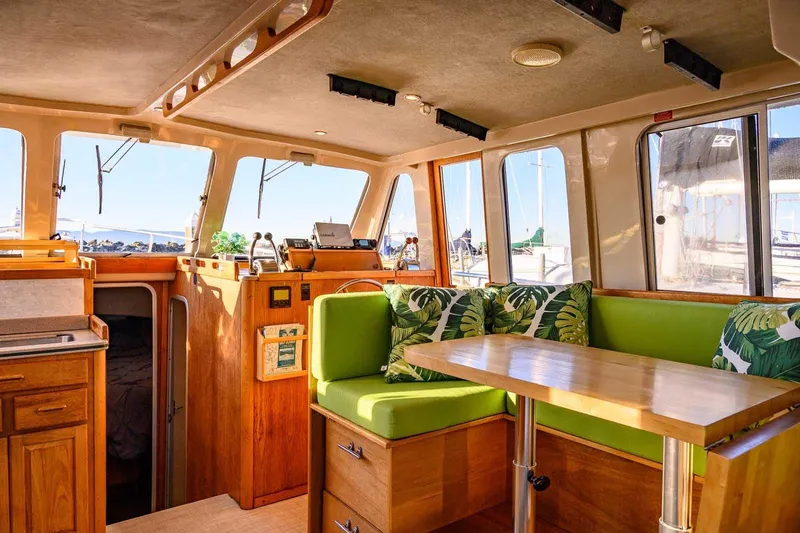 Slide: The Image of Interior of 1997 Mainship 350 Trawler with green seating and wooden accents. - 27