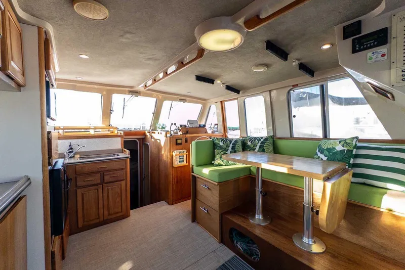 Slide: The Image of Interior of 1997 Mainship 350 Trawler with green seating and wooden cabinetry. - 28