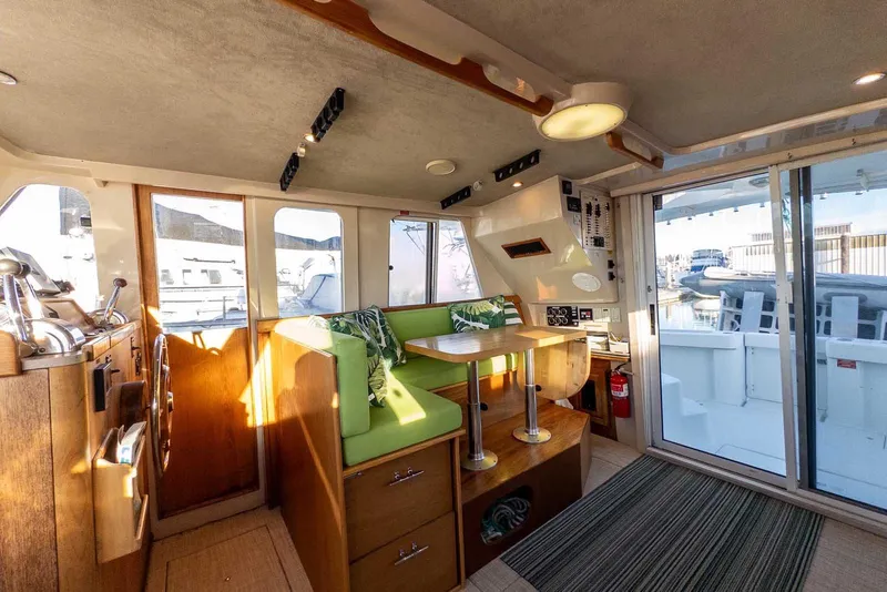 Slide: The Image of Interior of 1997 Mainship 350 Trawler with green seating and wooden accents. - 29