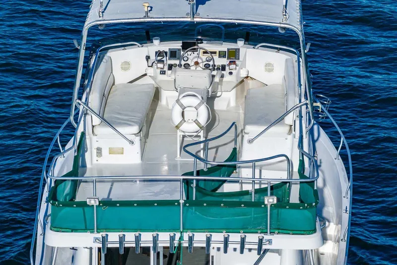 Slide: The Image of 1997 Mainship 350 Trawler boat deck with seating, steering, and ocean backdrop. - 3