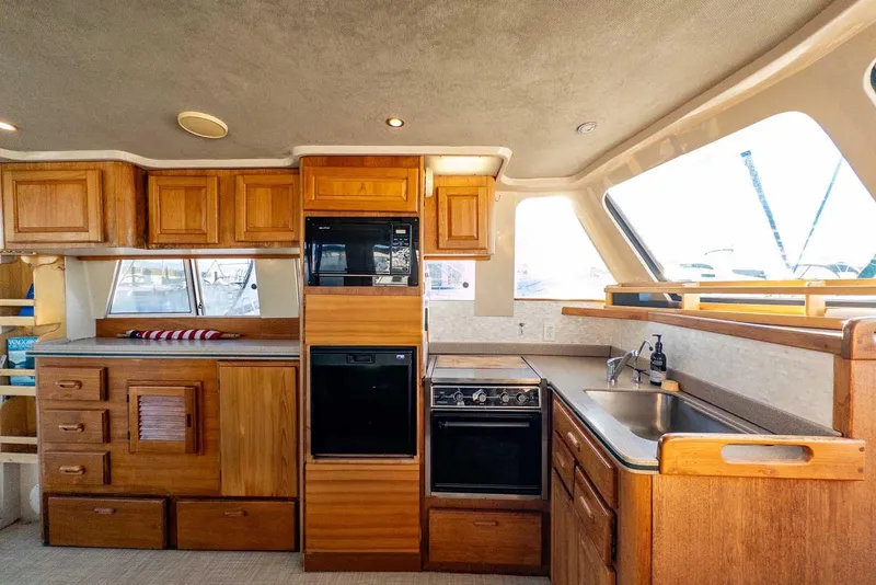 Slide: The Image of Interior of 1997 Mainship 350 Trawler kitchen with wooden cabinetry and modern appliances. - 33