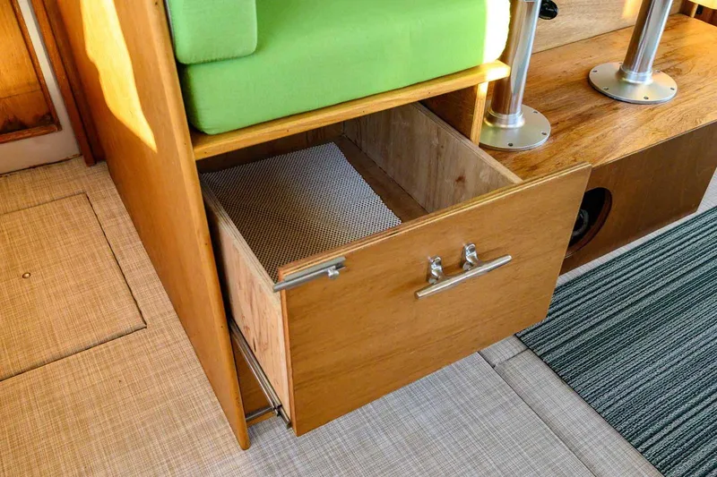 Slide: The Image of Open wooden drawer in 1997 Mainship 350 Trawler interior, green cushion above, carpeted floor. - 38