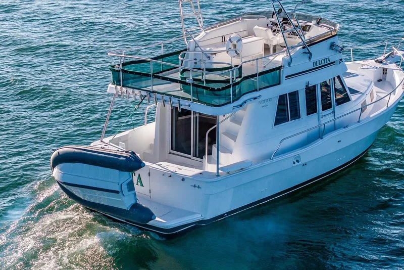 Slide: The Image of 1997 Mainship 350 Trawler cruising on open water, rear view. - 4