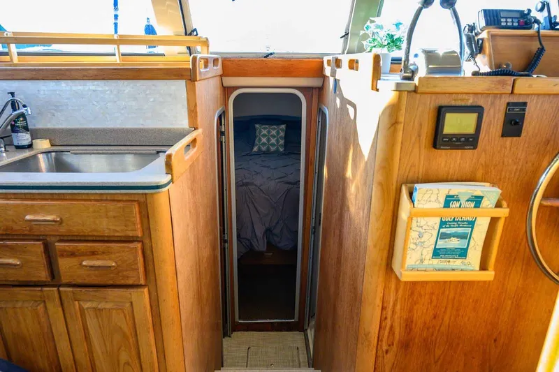 Slide: The Image of Interior of a 1997 Mainship 350 Trawler with wood cabinetry and cozy sleeping area. - 40