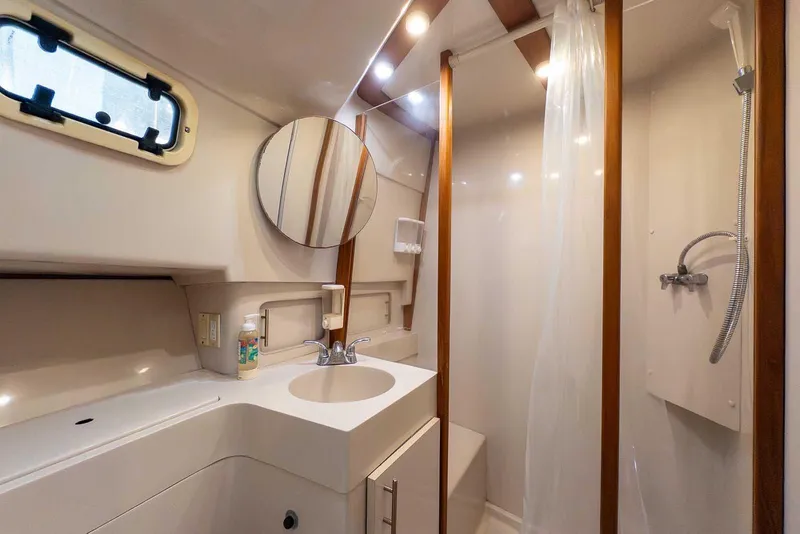 Slide: The Image of Bathroom of 1997 Mainship 350 Trawler with shower, sink, and mirror. - 43
