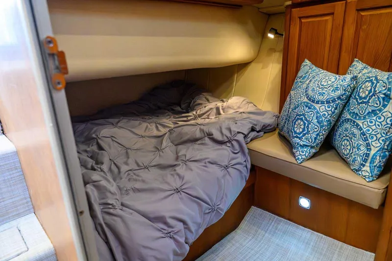 Slide: The Image of Cozy cabin interior of 1997 Mainship 350 Trawler with bed and decorative pillows. - 44